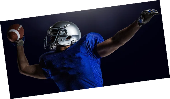 Quarterback de futebol americano a preparar-se para lançar a bola durante uma sessão fotográfica desportiva em estúdio